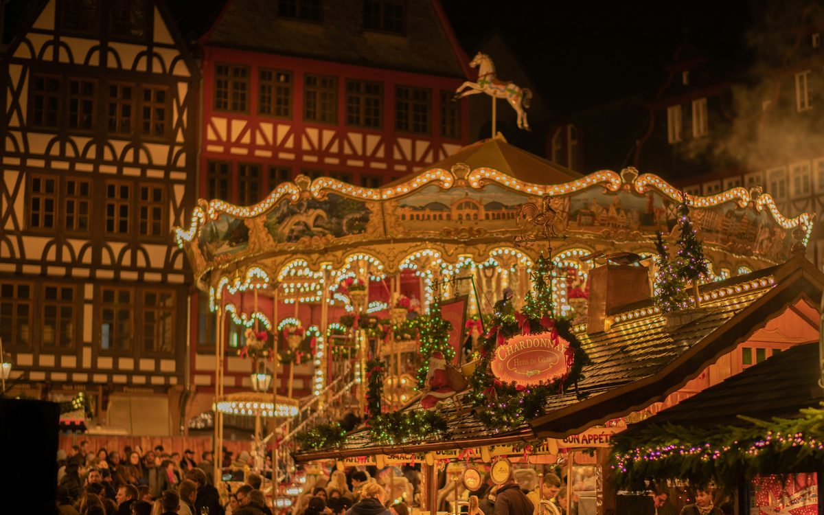 A lit carousel at a German Christmas market at night